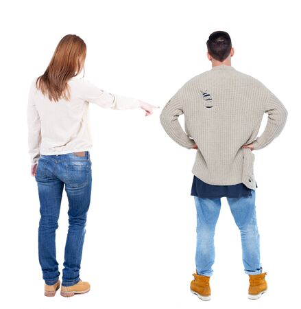 Back view of couple in sweater pointing. Rear view people collection. backside view of person. Isolated over white background.の写真素材