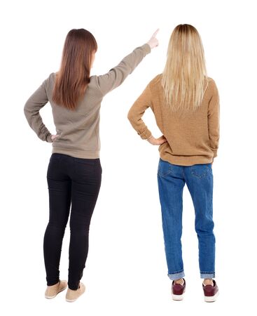 Back view of two pointing girl in sweater. Rear view people collection. backside view of person. beautiful woman showing gesture. Rear view. Isolated over white background.の写真素材