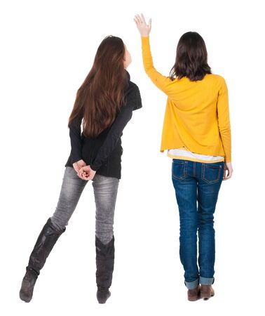 Back view of two pointing girl in sweater. Rear view people collection. backside view of person. beautiful woman showing gesture. Rear view. Isolated over white background.の写真素材