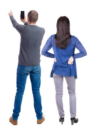 Back view of couple in sweater with mobile phone. beautiful friendly girl and guy together. Rear view people collection. backside view of person. Isolated over white background.の写真素材