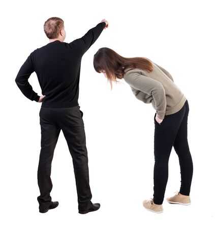 Back view of couple in sweater pointing. Rear view people collection. backside view of person. Isolated over white background.の写真素材