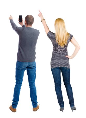 Back view of couple in sweater with mobile phone. beautiful friendly girl and guy together. Rear view people collection. backside view of person. Isolated over white background.の写真素材