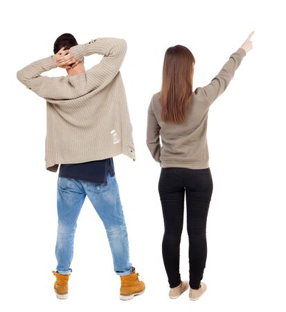 Back view of couple in sweater pointing. Rear view people collection. backside view of person. Isolated over white background.の写真素材