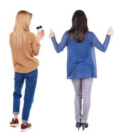 Back view of two woman in sweater showing thumb up. Rear view people collection. backside view of person. Rear view. Isolated over white background.の写真素材