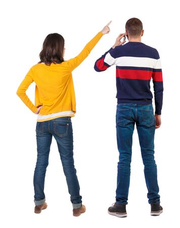 Back view of couple in sweater with mobile phone. beautiful friendly girl and guy together. Rear view people collection. backside view of person. Isolated over white background.の写真素材