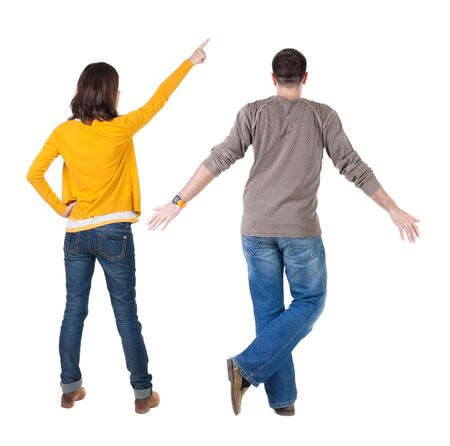 Back view of couple in sweater pointing. Rear view people collection. backside view of person. Isolated over white background.の写真素材