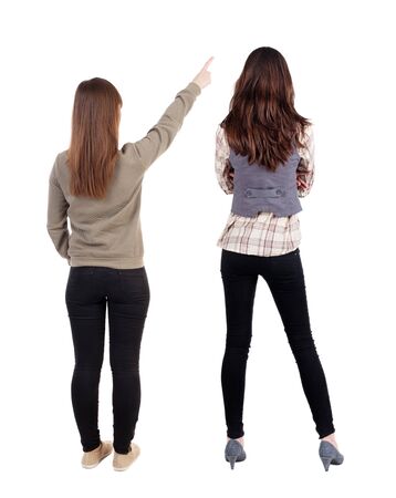 Back view of two pointing girl in sweater. Rear view people collection. backside view of person. beautiful woman showing gesture. Rear view. Isolated over white background.の写真素材