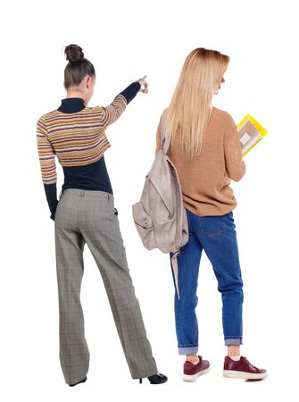 Back view of two pointing girl in sweater. Rear view people collection. backside view of person. beautiful woman showing gesture. Rear view. Isolated over white background.の写真素材