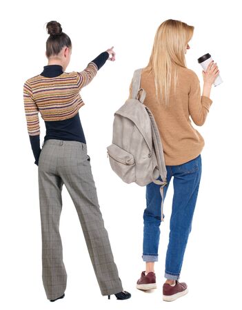 Back view of two pointing girl in sweater. Rear view people collection. backside view of person. beautiful woman showing gesture. Rear view. Isolated over white background.の写真素材