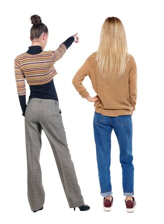 Back view of two pointing girl in sweater. Rear view people collection. backside view of person. beautiful woman showing gesture. Rear view. Isolated over white background.の写真素材