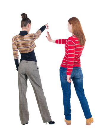 Back view of two pointing girl in sweater. Rear view people collection. backside view of person. beautiful woman showing gesture. Rear view. Isolated over white background.の写真素材