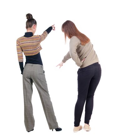 Back view of two pointing girl in sweater. Rear view people collection. backside view of person. beautiful woman showing gesture. Rear view. Isolated over white background.の写真素材