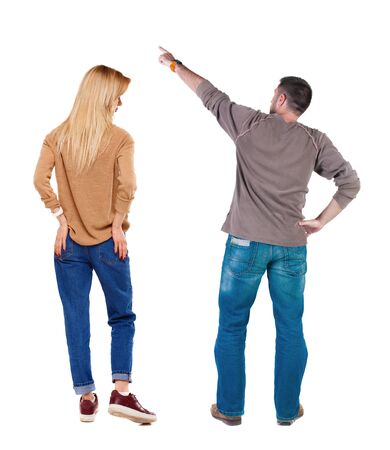 Back view of couple in sweater pointing. Rear view people collection. backside view of person. Isolated over white background.の写真素材
