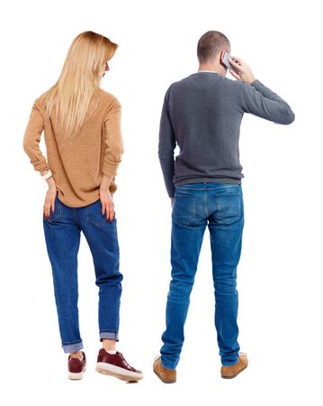 Back view of couple in sweater with mobile phone. beautiful friendly girl and guy together. Rear view people collection. backside view of person. Isolated over white background.の写真素材