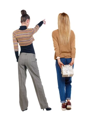 Back view of two pointing girl in sweater. Rear view people collection. backside view of person. beautiful woman showing gesture. Rear view. Isolated over white background.の写真素材