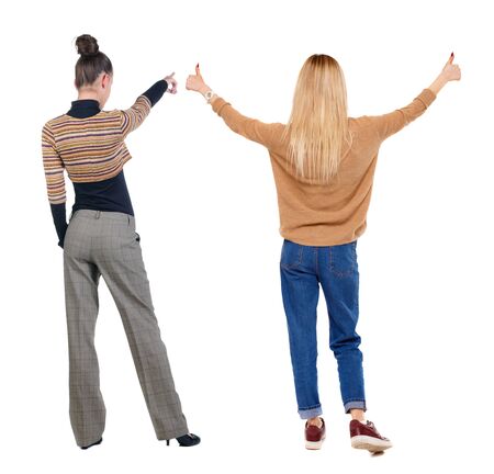 Back view of two pointing girl in sweater. Rear view people collection. backside view of person. beautiful woman showing gesture. Rear view. Isolated over white background.の写真素材