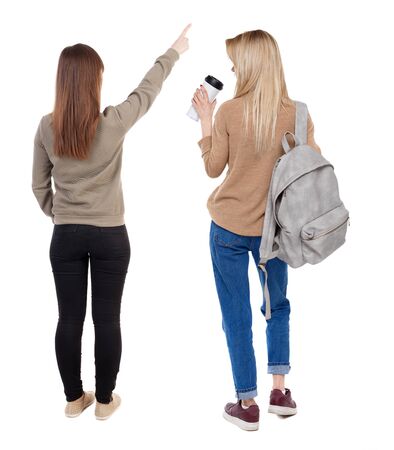Back view of two pointing girl in sweater. Rear view people collection. backside view of person. beautiful woman showing gesture. Rear view. Isolated over white background.の写真素材