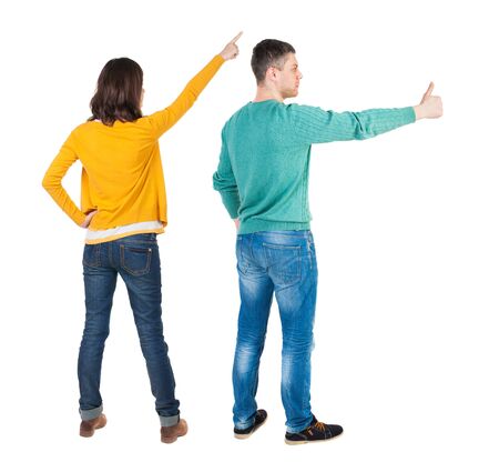 Back view of couple in sweater pointing. Rear view people collection. backside view of person. Isolated over white background.の写真素材