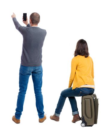 Back view of couple in sweater with mobile phone. beautiful friendly girl and guy together. Rear view people collection. backside view of person. Isolated over white background.の写真素材