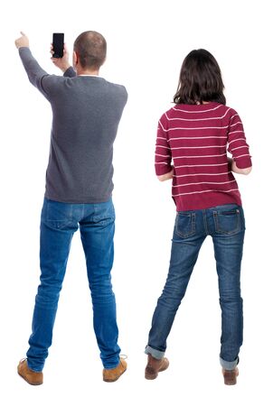 Back view of couple in sweater with mobile phone. beautiful friendly girl and guy together. Rear view people collection. backside view of person. Isolated over white background.の写真素材