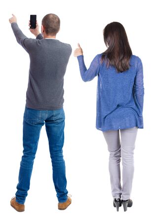 Back view of couple in sweater with mobile phone. beautiful friendly girl and guy together. Rear view people collection. backside view of person. Isolated over white background.の写真素材
