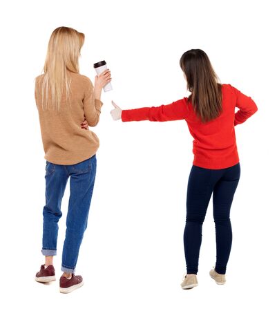 Back view of two woman in sweater showing thumb up. Rear view people collection. backside view of person. Rear view. Isolated over white background.の写真素材