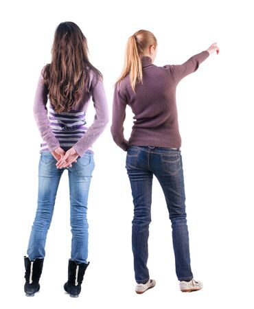 Back view of two pointing girl in sweater. Rear view people collection. backside view of person. beautiful woman showing gesture. Rear view. Isolated over white background.の写真素材