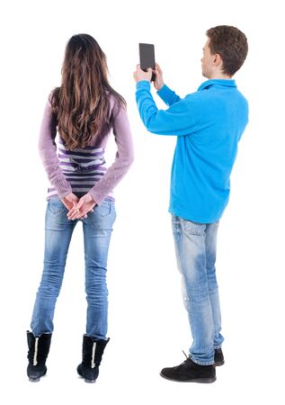 Back view of couple in sweater with mobile phone. beautiful friendly girl and guy together. Rear view people collection. backside view of person. Isolated over white background.の写真素材