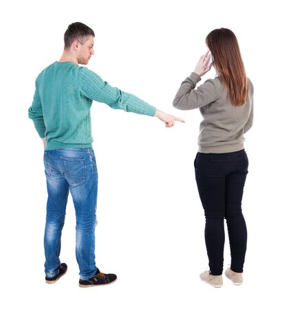 Back view of couple in sweater pointing. Rear view people collection. backside view of person. Isolated over white background.の写真素材