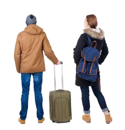 young couple in winter jacket traveling with suitcas. Back view. Rear view people collection. backside view of person. Isolated over white background.の写真素材