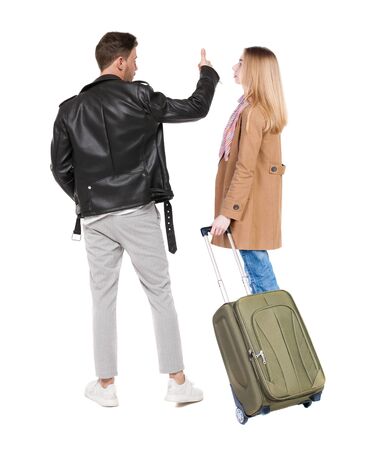 young couple in winter jacket traveling with suitcas. Back view. Rear view people collection. backside view of person. Isolated over white background.の写真素材