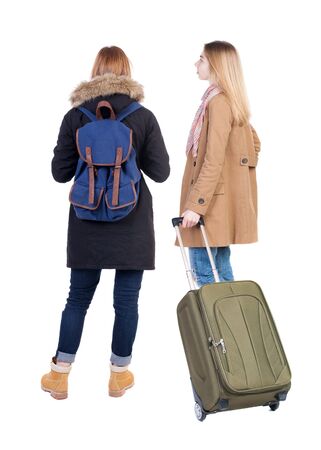 Back view of two woman in winter jacket traveling with suitcas. Back view. Rear view people collection. backside view of person. Isolated over white background.の写真素材