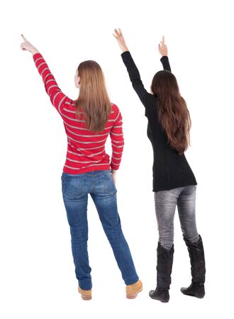 Back view of two pointing girl in sweater. Rear view people collection. backside view of person. beautiful woman showing gesture. Rear view. Isolated over white background.の写真素材