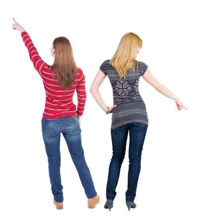 Back view of two pointing girl in sweater. Rear view people collection. backside view of person. beautiful woman showing gesture. Rear view. Isolated over white background.の写真素材