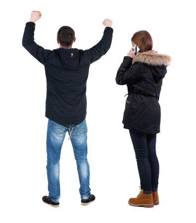 Back view of couple in winter jacket photographed on a mobile phone in winter jacket. beautiful friendly girl and guy together. Rear view people collection. backside view of person. Isolated over white background.の写真素材