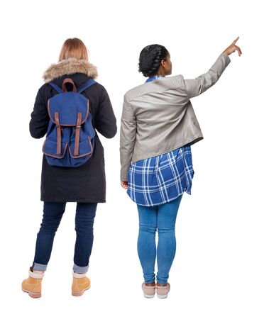 Back view of two pointing girl in winter jacket. Rear view people collection. backside view of person. beautiful woman friends showing gesture. Rear view. Isolated over white background.の写真素材