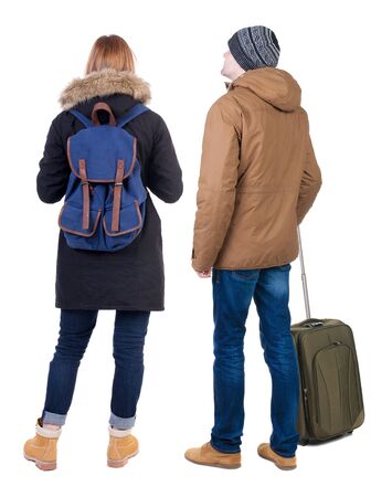 young couple in winter jacket traveling with suitcas. Back view. Rear view people collection. backside view of person. Isolated over white background.の写真素材