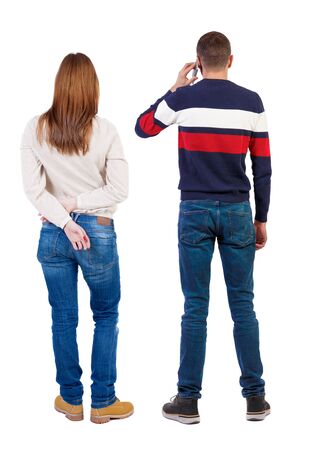 Back view of couple in sweater with mobile phone. beautiful friendly girl and guy together. Rear view people collection. backside view of person. Isolated over white background.の写真素材