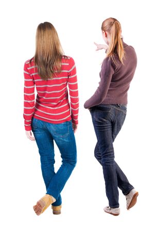 Back view of two pointing girl in sweater. Rear view people collection. backside view of person. beautiful woman showing gesture. Rear view. Isolated over white background.の写真素材
