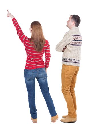 Back view of couple in sweater pointing. Rear view people collection. backside view of person. Isolated over white background.の写真素材