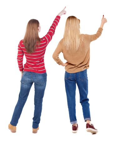 Back view of two pointing girl in sweater. Rear view people collection. backside view of person. beautiful woman showing gesture. Rear view. Isolated over white background.の写真素材