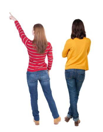 Back view of two pointing girl in sweater. Rear view people collection. backside view of person. beautiful woman showing gesture. Rear view. Isolated over white background.の写真素材