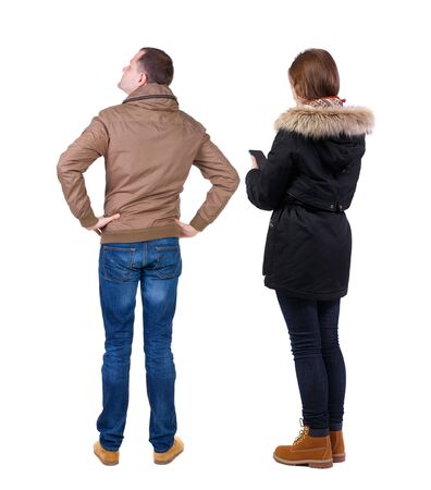 Back view of couple in winter jacket photographed on a mobile phone in winter jacket. beautiful friendly girl and guy together. Rear view people collection. backside view of person. Isolated over white background.の写真素材