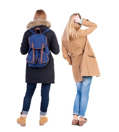 Back view of two young woman in winter jackets. Rear view people collection. backside view of person. Rear view. Isolated over white background. She clung to his girlfriendの写真素材