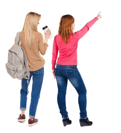 Back view of two pointing girl in sweater. Rear view people collection. backside view of person. beautiful woman showing gesture. Rear view. Isolated over white background.の写真素材