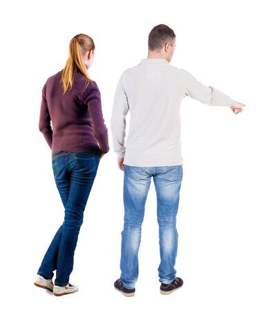 Back view of couple in sweater pointing. Rear view people collection. backside view of person. Isolated over white background.の写真素材
