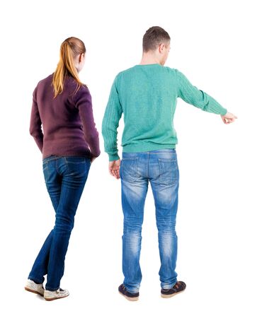 Back view of couple in sweater pointing. Rear view people collection. backside view of person. Isolated over white background.の写真素材
