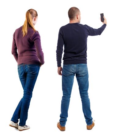 Back view of couple in sweater with mobile phone. Rear view people collection. backside view of person. Isolated over white background.の写真素材