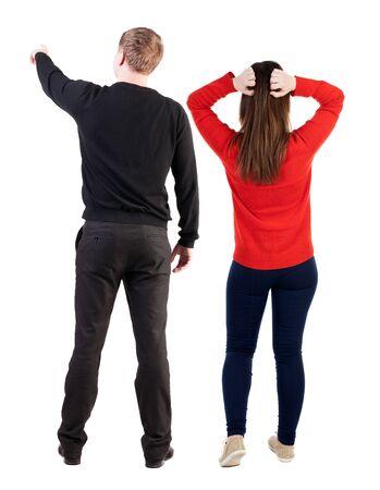 Back view of couple in sweater pointing. Rear view people collection. backside view of person. Isolated over white background.の写真素材