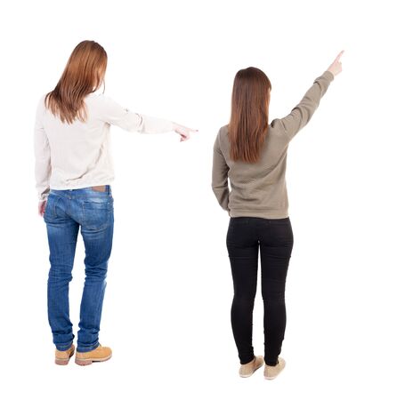 Back view of two pointing girl in sweater. Rear view people collection. backside view of person. beautiful woman showing gesture. Rear view. Isolated over white background.の写真素材